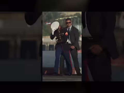 جندي أميركي يحافظ على قبعة أمام رياح طائرة الرئيس ترمب