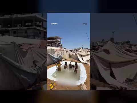 أطفال فلسطينيون يلعبون في بركة مياه وسط غزة