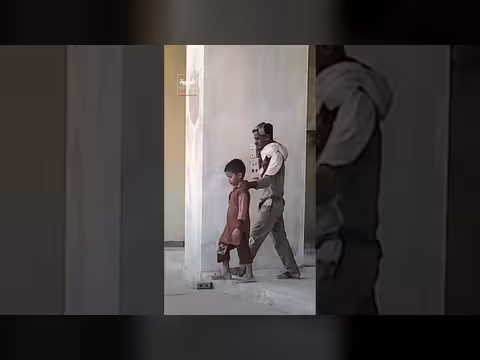 أب كفيف يقوده ابنه في العمل