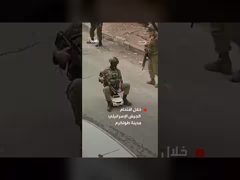 جندي إسرائيلي يلهو بلعبة طفل خلال اقتحام طولكرم